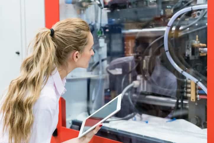 Horizontal color image of woman manager in factory control the production and using digital tablet.