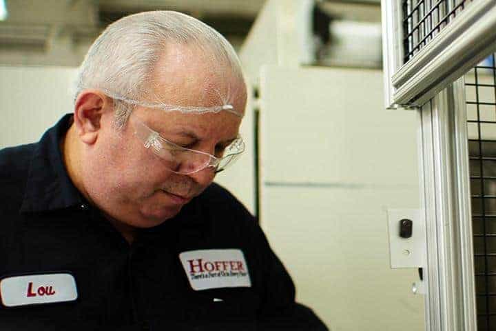 hoffer employee with hair net looking down