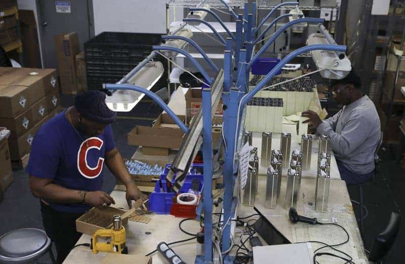 AllCell Technologies employee Jerlene Jackson uses a heat gun to wrap rechargeable battery cells. (Abel Uribe / Chicago Tribune)